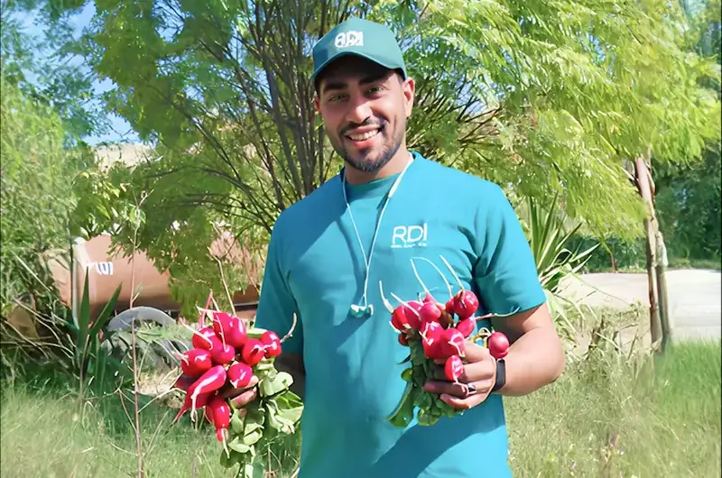 RDI Testimonail 7 RDI team member holding freshly harvested red radishes.